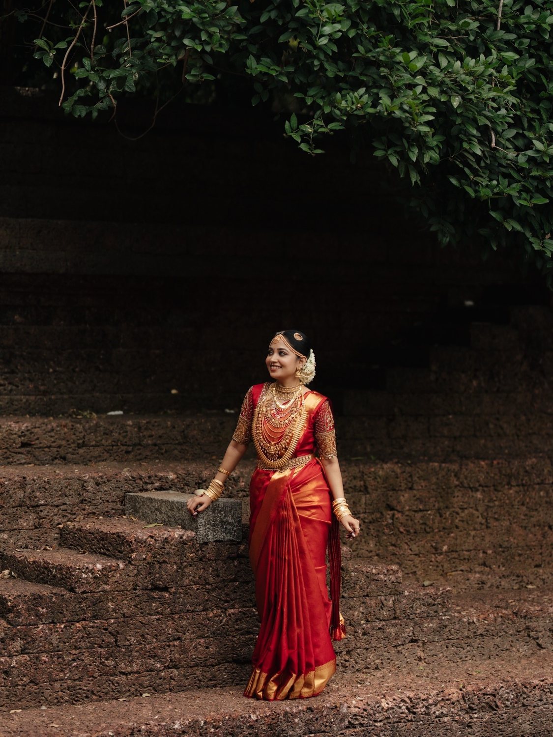 Bride in red walking in dappled light